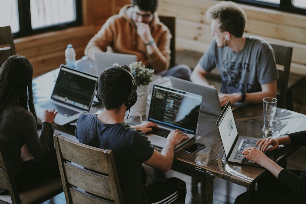 Adults sharing ideas around laptops at a study table