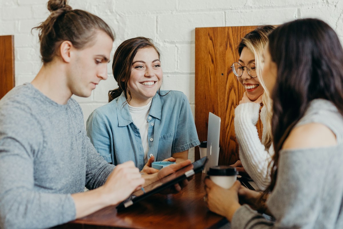 Adults gathered around a table with laptops and notebooks
